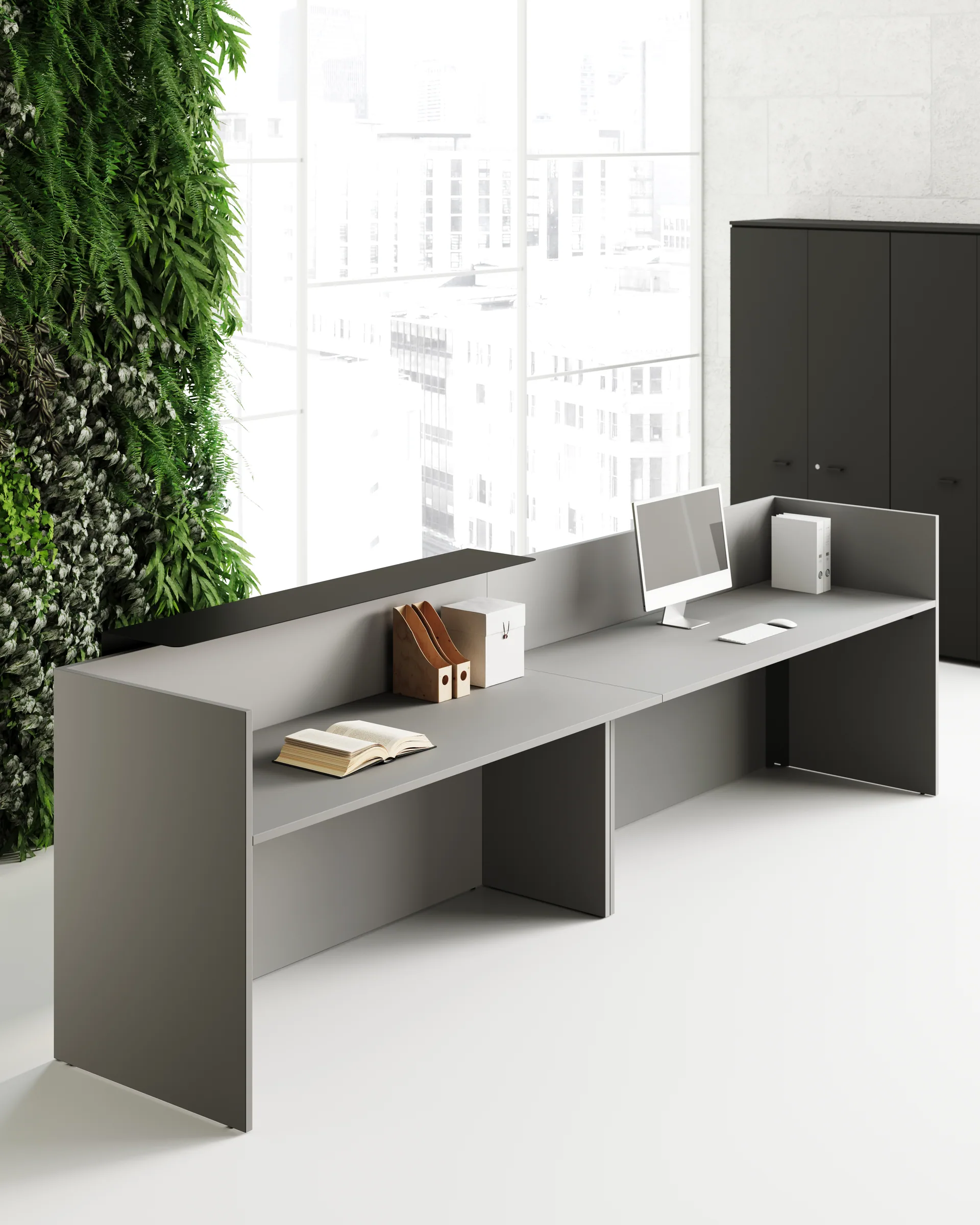 Bancone reception Dot grigio a doppia postazione, con piano frontale sopraelevato, fianchi sottopiano, parete verde e vetrate luminose sullo sfondo.