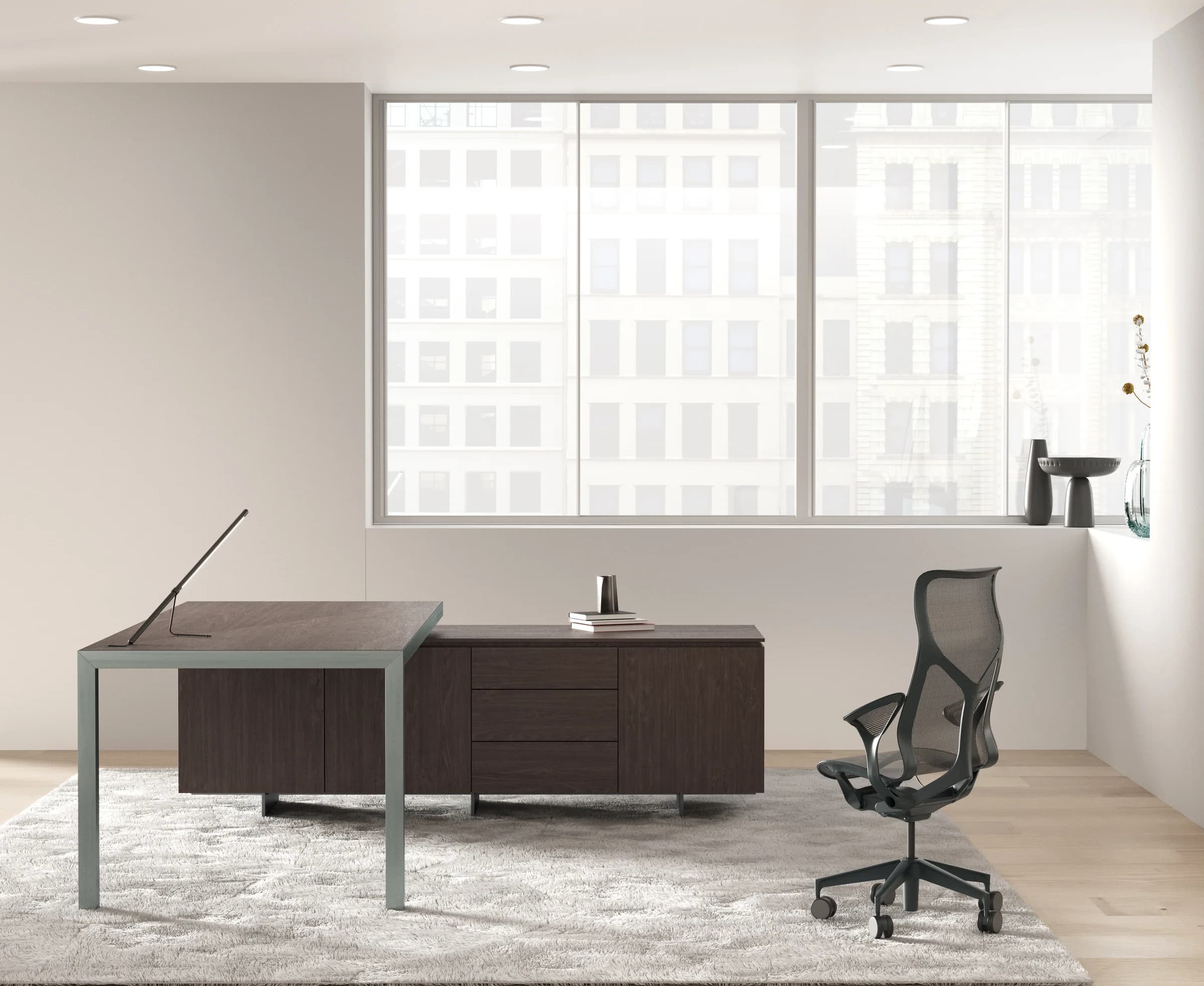 Scrivania direzionale Galvano con piano in rovere scuro su struttura grigia sottile, credenza coordinata e poltrona in rete