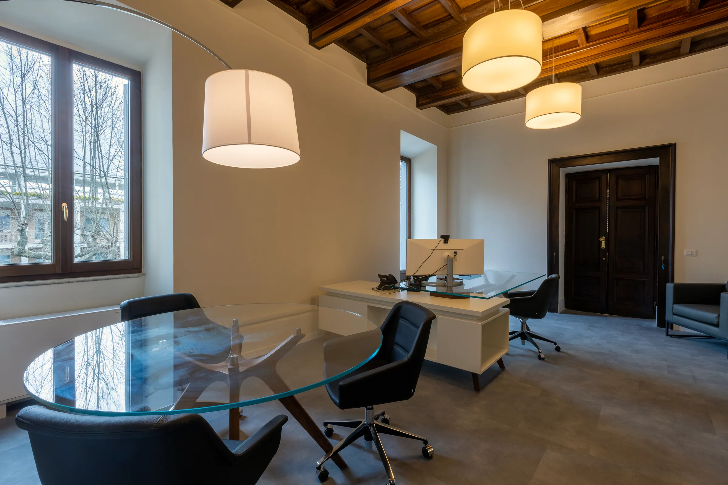 Piccola sala riunioni da quattro posti integrata nell'ufficio presidenziale, elegante e luminosa.