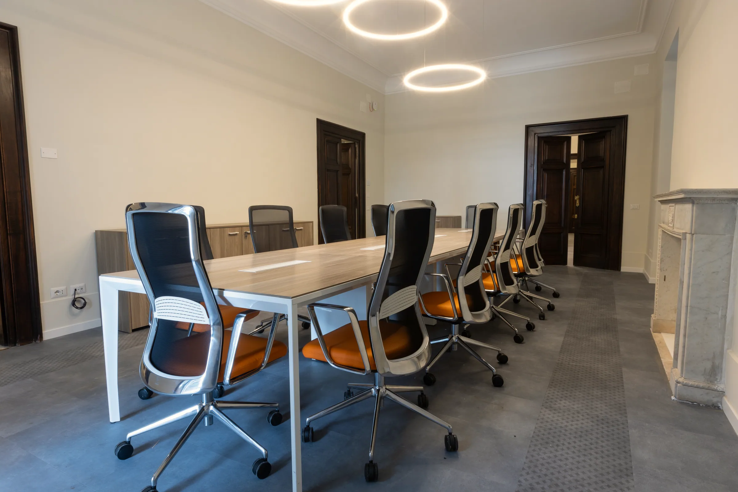 Sala riunioni da dieci posti con arredi contemporanei inseriti in un elegante edificio ottocentesco restaurato.