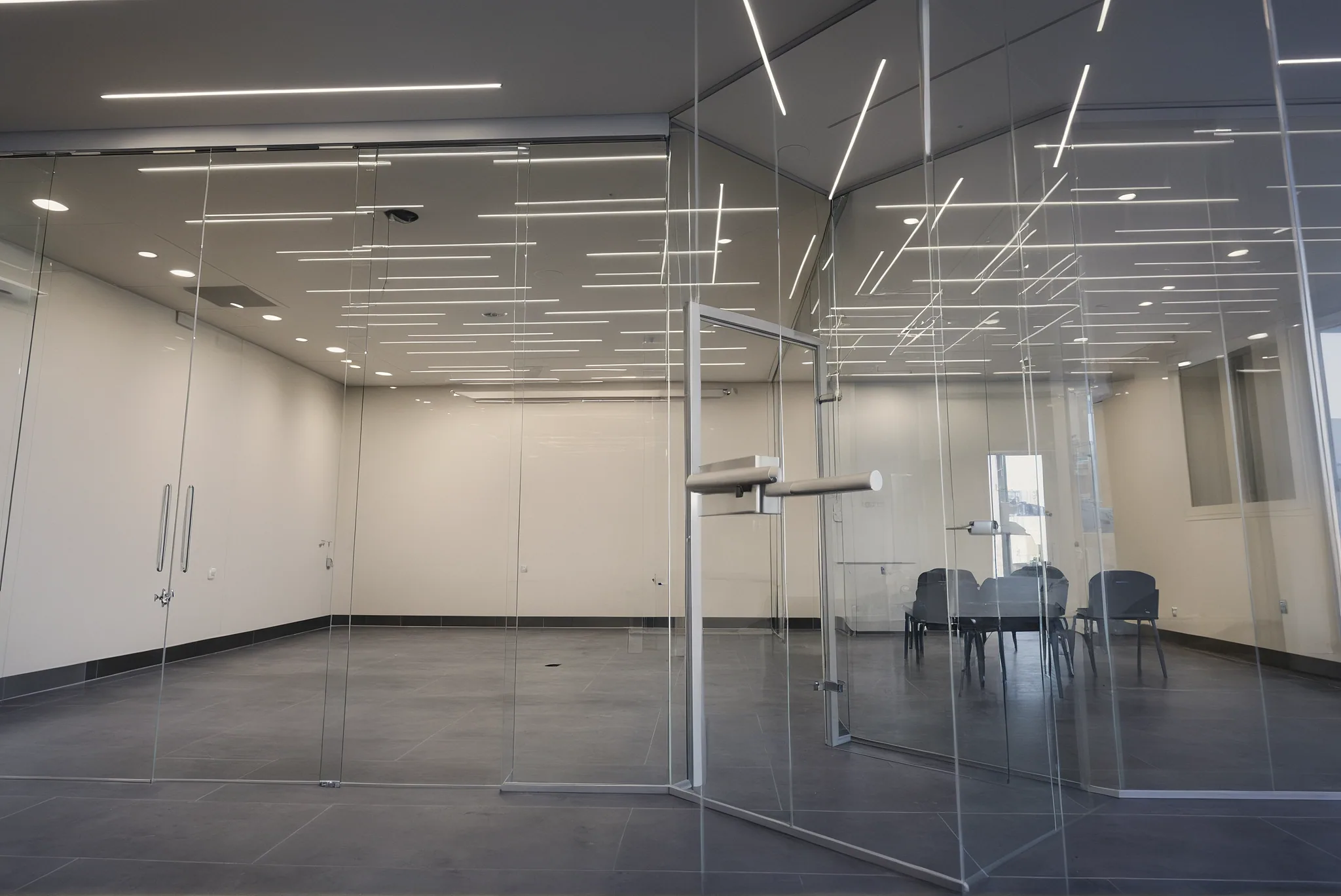 Parete in vetro a tutta altezza in un ufficio in uso, con la luce che attraversa