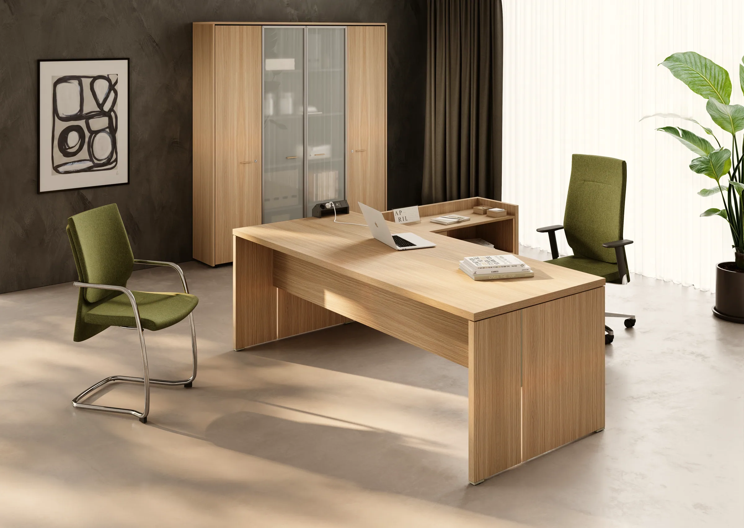 Ufficio direzionale con scrivania a L della linea Gamma in rovere chiaro: piano principale con fianchi a pannello e allungo laterale rialzato dotato di presa elettrica integrata.