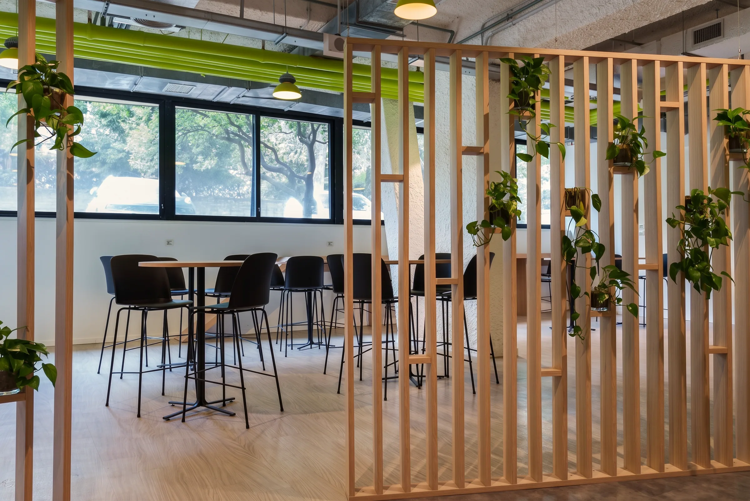 Reception con parete vegetale verde, logo SMI a rilievo bianco e bancone chiaro