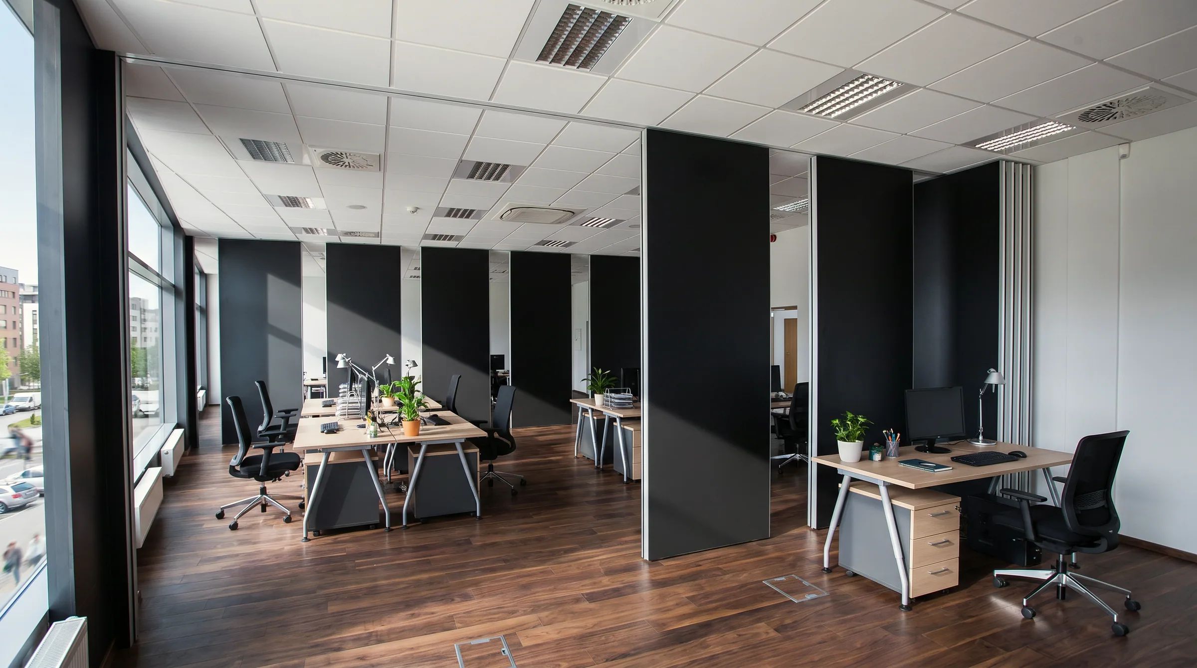 Open space con pareti manovrabili a pannelli scuri aperte fra le postazioni di lavoro